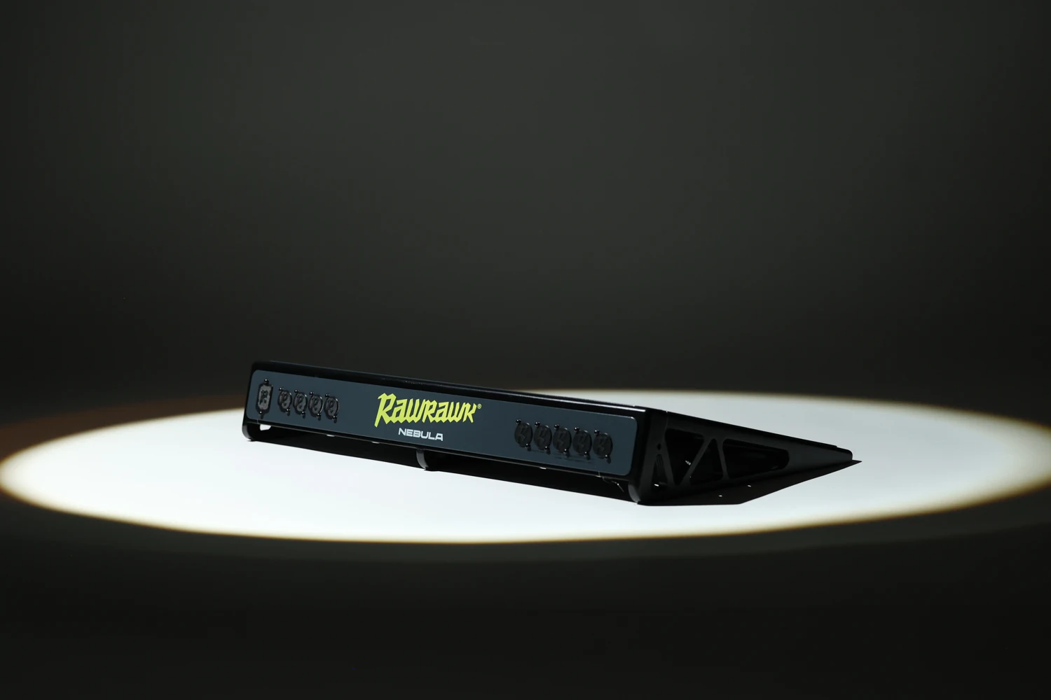 The complete Nebula pedalboard showing its angled side and rear connector panel under studio lighting